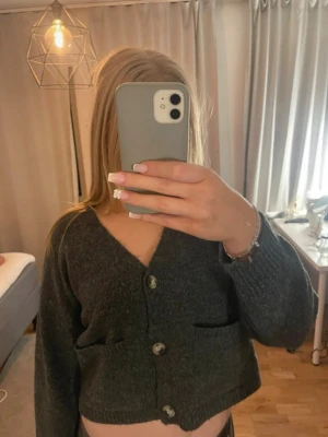 Grå kort stickad kofta - Knappt använd. Relativt kort modell!