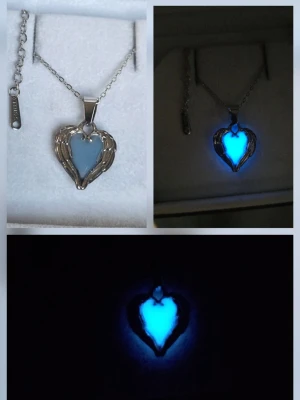 Glow in the dark hjärthalsband - Unikt handgjort halsband med ett hjärtformat hänge i silverfärgad metall och blått självlysande inlägg. Hänget är ca 1,8 cm och har detaljer som liknar vingar runt hjärtat. Kedjan är tunn och silverfärgad i rostfritt stål med justerbar längd. Perfekt för dig som gillar smycken som sticker ut och lyser i mörkret. Effekten aktiveras av vanligt dagsljus och solljus o lyser vanligtvis i flera timmar (12h+) vid normal användning. Tål vatten & missfärgas ej.