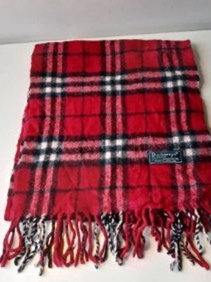 Röd rutig halsduk från Burberrys - Klassisk röd halsduk från Burberrys i 100% lammull. Halsduken har ett rutigt mönster i svart, vitt och grått samt fransar i ändarna. Perfekt accessoar för att lyfta din outfit med en tidlös brittisk stil.