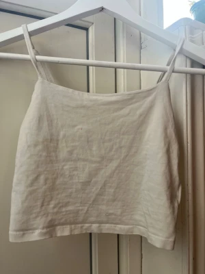 Vit linnetopp från 157 - Säljer en enkel och fräsch vit linnetopp från 157 i storlek XS. Toppen har smala axelband och är tillverkad i en mjuk bomullsblandning med lite stretch. Perfekt till sommaren och lätt att matcha med allt.