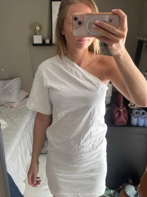 Student klänning! - Så snygg vit klänning med one shoulder! Perfekt till studneten, skolavslutningen eller bara till sommaren! Ny pris ca 700, köpt från arket för något år sedan, kanppt använd.