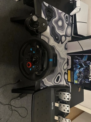 Sony PlayStation 5 och Logitech racerratt  - PlayStation 5 Fortnite Edition i vit med tillhörande DualSense-kontroll. Konsolen har en futuristisk design i plast och levereras med originalkartong. På bilderna syns även ett Logitech racerratt och pedaler, perfekt för gaming.
