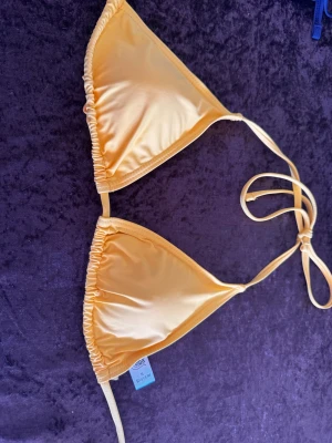 Gul trekantsbikini med knyt - Snygg gul trekantsbikini från en marknad i Spanien med klassisk knytning i nacken och ryggen. Perfekt för stranden eller poolen, enkel och stilren design som ger en fräsch sommarkänsla.