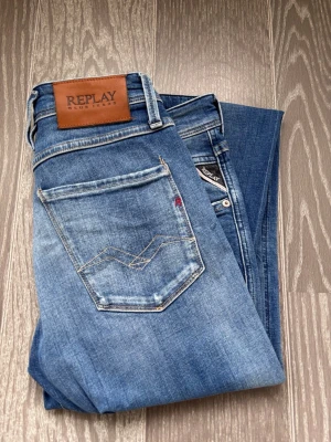 Blå slitna jeans från Replay - Säljer ett par blåa Replay jeans med slitningar. Jeansen är i storlek 29/32. Har använt dem väldigt fåtal gånger. Hör av er vid frågor.