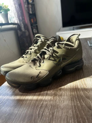 Nike Air Vapormax olivgröna sneakers - Nike Air Vapormax sneakers i olivgrönt med klassisk swoosh på sidan. Ovandel i textil och syntet, med unika bubbliga sulor för extra komfort och stil. Snygga snörningar och sportig vibe, perfekta för dig som gillar streetwear och vill sticka ut.
