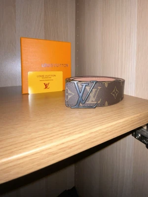 Snygg monogram bälte - Snygg brun bälte med klassiskt monogrammönster. Bältet har en exklusiv känsla och är perfekt för att lyfta vilken outfit som helst.