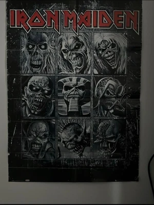 Iron Maiden poster med albummotiv - Stor poster med Iron Maiden-tryck i svart och vitt, prydd med bandets logga i rött och flera ikoniska Eddie-motiv från olika album. Perfekt för fans av hårdrock och samlare av bandmerch. Affischen har en rå och mörk design med detaljerade illustrationer.