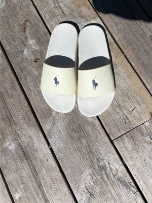 Vita slides från Polo Ralph Lauren - Snygga vita slides från Polo Ralph Lauren perfekt till sommaren tveka inte vid frågor.