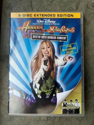 Hannah Montana & Miley Cyrus dvd - Hannah Montana & Miley Cyrus: Best of Both Worlds Concert är en 2-disc Extended Edition DVD. Filmen är från 2008 och har en speltid på 90 minuter. Ljudet är i Dolby Digital 5.1 och 2.0. Textning finns på svenska, danska, norska, finska, engelska och isländska.  Finns på språk: Engelska   OBS!! skivorna är begagnade så det kan förekomma repor/hairlines på skivorna, men då jag kollar igenom alla filmer jag säljer garanterar jag att alla funkar felfritt om inget annat står! :)  OBS! Inga glasögon