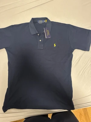 Polo ralph lauren piké  - Polo piké helt ny mörkblå med gul logga. Perfekt för sommaren