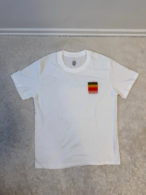 Vit Casa Blanca t-shirt med tryck - Snygg vit t-shirt från Casa Blanca med ett färgglatt tryck i rött, gult och grönt på bröstet. Klassisk passform och rund halsringning, perfekt för en chill och stilren look.