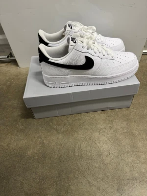 Nike Air Force 1 '07 Vita/Svarta Sneakers, Strl 44 - Helt nya Nike Air Force 1 '07 Vita/Svarta Sneakers, Strl 44.  Skorna har inte blivit använda eller testade.  Original kartong medföljer. Nypris hos Nike 1400 kr