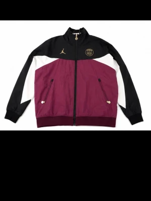 PSG x Jordan vindjacka - Riktigt snygg och bekväm vindjacka. Köpt för längesen men inte använd så mycket för jag växte ur den. Väldigt detaljerad och snygga loggor på dragkedjor, vid nacken osv. Hittar inte storleken någonstans men har för mig att den är medium. Kan skicka mått om du frågar!