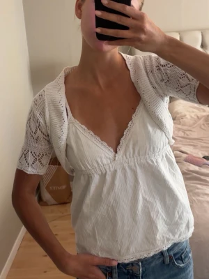 Vit virkad bolero med kort ärm - Söt vit bolero i virkad stil med korta ärmar och öppet mönster. Perfekt att slänga över ett linne eller klänning för en extra detalj😙❣️