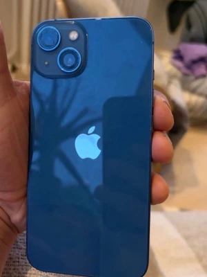 Blå Apple iPhone med dubbla kameror - Snygg blå iPhone med stilren design och två kameror på baksidan. Mobilen har en glansig baksida med Apple-loggan och rundade hörn. Perfekt för dig som gillar modern teknik och vill ha en färgstark smartphone. Ena kameran är sönder! Batterihälsa 87%