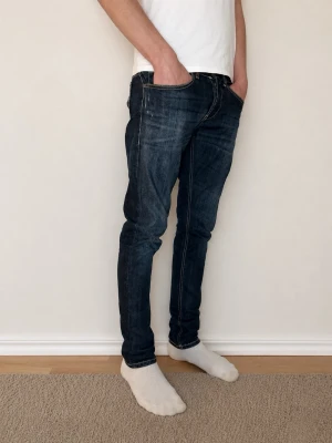 Dondup George - Säljer ett par snygga Dondup George. Färgen är mörkblå med sköna fades och jeansen har schyssta slitningar från tillverkning. Storleken är W31 och modellen är tight/slim fit. Jeansen har även en skön stretch. Skicket är mycket bra, jeansen är varsamt använda. Det är de mest eftertraktade jeansen på marknaden med ett nypris på ungefär 3000! Mitt pris är 799 men jag är öppen för prisförslag! Kontakta mig vid minsta lilla fundering!