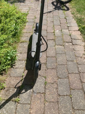 Svart elscooter från NEROX - Säljer en svart elscooter från NEROX med robust ram och bred fotplatta. Scootern har blå detaljer, stora hjul och stöd. Perfekt för att ta sig runt i stan på ett smidigt och miljövänligt sätt. Laddningsuttag och broms bak syns tydligt.