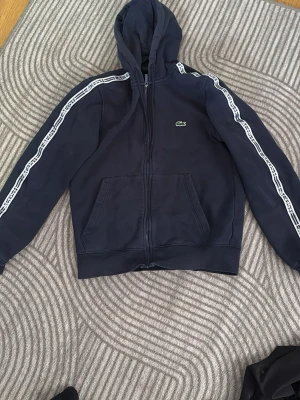 Mörkblå hoodie från Lacoste - Snygg mörkblå hoodie från Lacoste med dragkedja storlek S 