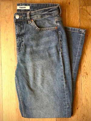 Cropped flare jeans regular waist - Jeans från Kappahl (original pris: 499). Croppade jeans i flare-modell med normalhög midja. Jeansen har en kortare benlängd med något utsvängda ben. Jeans i klassisk 5-ficksmodell. Stretchig denimkvalitet. Gylf med dragkedja och knapp. Innerbenslängd: 70 cm