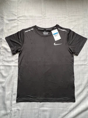 Nike miler T-shirt svart strl M - Säljer en helt ny Nike T-shirt i svart färg. Väldigt clean modell och perfekt till sommaren. Enkel att matcha och passar till allt. Oanvänd i storlek M. 