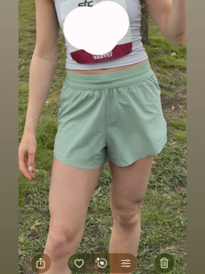 Nike Swift löparshorts 2-i-1 - Snygga mintgröna löparshorts från Nike med elastisk midja och lätt, snabbtorkande material. Perfekta för löpning eller träning, med en avslappnad passform och diskret Nike-logga på benet. Ficka baktill, perfekt att ha mobilen i. Endast använda 1 gång. Säljer för 499kr, Nypris: 749kr💚
