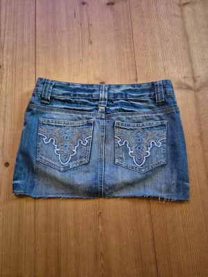 Jeanskjol med broderade bakfickor - Skitsnygg jeanskjol med låg midja och detaljer på bakfickorna. Köpte vintage så vet tyvärr inte märke eller storlek, men skulle säga att dom är s/xs💓