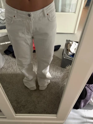 Vita raka jeans med mid/hög midja - Säljer ett par vita jeans med rak passform och mid midja.  Jeansen har lite tvättmedels fläckar på baksidan(se bild). (Jag är en S som referens)