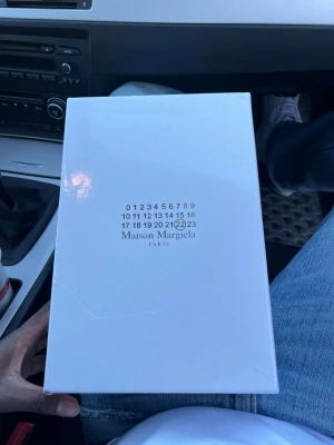 Maison Margiela blå sneakers - Maison Margiela sneakers i en snygg blå färg med vita snören och beige sula. Skorna har en mix av mocka och skinn, vilket ger en lyxig känsla. Perfekta för dig som vill sticka ut med stilrena och trendiga sneakers.
