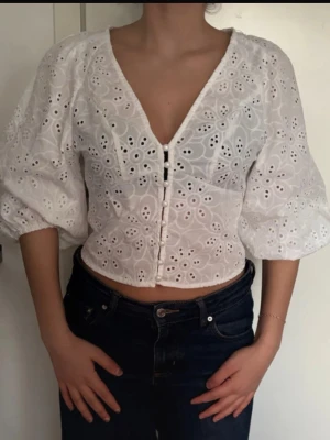 Vit blus med puffärm - Superfin vit blus med broderade hålmönster och knappar framtill. Köpt på Vinted men aldrig använt och den tidigare köparen har knappt använt den heller. Skriv gärna vid frågor eller för fler bilder!
