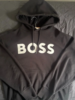 Svart BOSS hoodie - Svart boss hoodie, storleken är M. Inga deffekter alls, passformen är lite stor. Kom dm för fler bilder eller om ni har frågor.