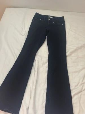 Bootcut jeans från Perfect Jeans - Svarta bootcut jeans från Perfect Jeans med klassisk femficksdesign och knappgylf. Jeansen har utsvängda ben och är tillverkade i ett stretchigt denimtyg som sitter snyggt. Perfekta för dig som gillar en retroinspirerad look.