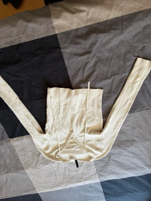 Beige ribbad långärmad topp - Säljer en beige ribbad topp med lång ärm och snygg snörning framtill. Perfekt för dig som gillar en enkel men trendig look. Materialet är mjukt och stretchigt, vilket gör den bekväm att bära hela dagen. Passar till många olika outfits!