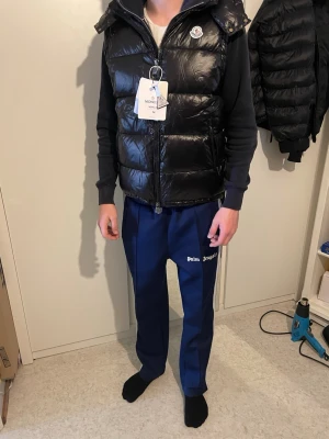 Svart dunväst  - Tja alla! Säljer denna fina och mycket bra kvalité väst. Den ser luftig ut eftersom den har varit vakuum paket. Men den löser upp sig! Säljes för 979:- skickas samma dag! Storlek M:)