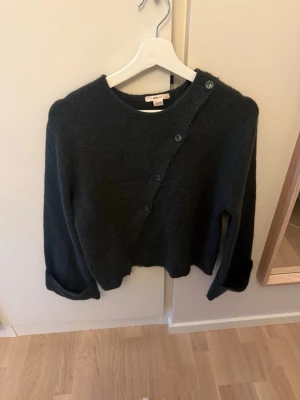Mörkgrön stickad tröja  med sned knäppning - Säljer en mörkgrön stickad tröja med knappar på från Gina Tricot. Jätte skön och fin tröja, knappt använd endast 1 gånger så som ny!💕