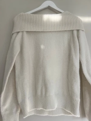 Kräm vit stickad off shoulder tröja ifrån Lindex  - Säljer denna kräm vita stickade tröja med bred ribbad off shoulder-krage och långa ärmar i storlek 158/164.Tröjan har ribbade muddar vid ärmarna och nederkant.
