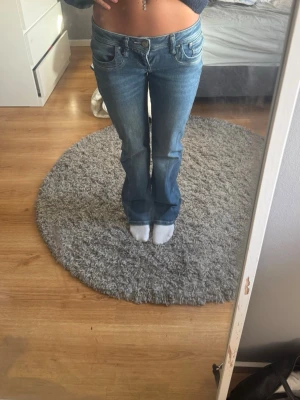 Blå bootcut jeans från Valerie - Säljer ett par blå bootcut jeans från ltb med klassisk femficksmodell och låg midja. Jeansen har snygg tvättad look och är tillverkade i denim med lätt stretch. Perfekta för dig som gillar en avslappnad men trendig stil.