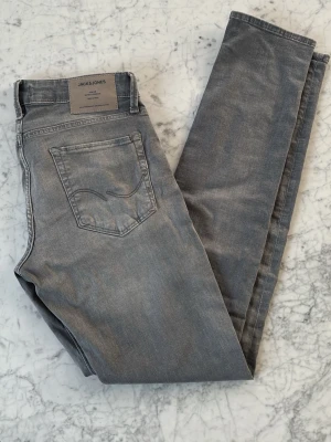 Jack & Jones jeans - Säljer dessa riktigt snygga ljusgråa jeans från Jack & Jones med slim passform. | Modell: Slim/Glenn | Skick: 10/10. (NYA) | Storlek: 30/34 | Nypris: 1200kr | Vårt pris: 399kr | Tveka inte att höra av dig vid minsta fråga! Mvh