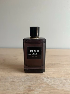 French Club For Him parfym - Stilren parfym för honom från French Club i en mörkbrun, fyrkantig glasflaska med svart etikett och gulddetalj vid halsen. Flaskan har en svart, blank kork och ger ett elegant intryck. Perfekt för dig som gillar klassisk och maskulin design. Luktar också väldigt gott och jag har bara använt den säker 20 sprut. Lägg bud, jag svarar snabbt👍🏽