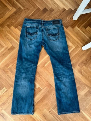 Ariat m7 - Säljer ett par blå jeans från Ariat i storlek 34/34. Jeansen har tvättade detaljer för en avslappnad look. Bakfickorna har snygga sömmar och materialet är robust denim i bomull. Säljes pga att jag köpte de secondhand o de ej passade 