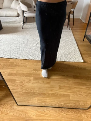 Mörkblå långkjol från 157 - Säljer en oanvänd mörkblå långkjol från 157 i storlek M. Kjolen har en enkel och rak passform med resår i midjan. Perfekt att styla med både sneakers och boots för en clean look. 