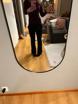 Svarta kostymbyxor - Säljer ett par svarta bootcut kostymbyxor med snygg passform och klassisk look. Byxorna har låg midja och är tillverkade i ett mjukt material som sitter bekvämt. Perfekta för dig som vill ha en stilren och trendig vibe. De har en slits nertill💕