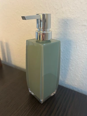 Tvålpump - En tvålpump med en elegant design. Pumpen är i silverfärg och flaskan har en grönaktig nyans. Passar bra i badrummet eller köket.  Obs i begagnat skick!