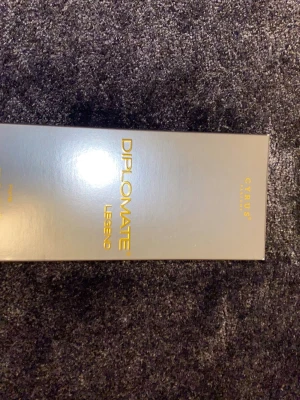 Diplomate Legend parfym (har andvänds 4-10 gånger) - Diplomate Legend från Cyrus är en parfym med modern design. Flaskan är rektangulär i genomskinligt glas med svart sprayhuvud och detaljer. Förpackningen är stilren i grått med guldfärgad text. Perfekt för dig som gillar exklusiva dofter.
