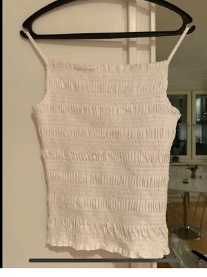 Vit smockad top - Liten i strl, mer en M än en L