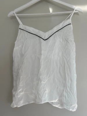 Vit satin linne med svart detalj ifrån Cubus - Säljer detta vita satin linne med svart detalj ifrån Cubus i storlek xs. Endast använd vid ett tillfälle.