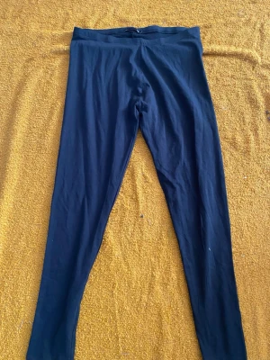 Svarta basic leggings - Svarta leggings med hög midja och smal passform. Mjukt och stretchigt material som sitter skönt mot kroppen. Perfekta att matcha med oversized tröjor eller hoodies. Klassisk och enkel design utan synliga detaljer.