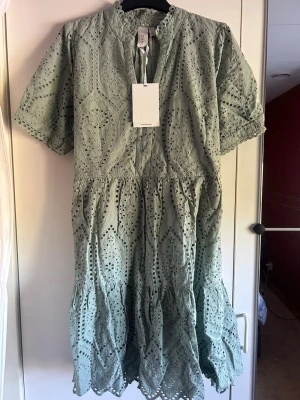 Grön broderad klänning från YAS - Superfin ljusgrön klänning från YAS i broderad bomull med kort ärm och vacker volangkant nertill. Perfekt för vår och sommar med sitt luftiga material och detaljerade mönster. Aldrig använd!💗originalpris 849kr