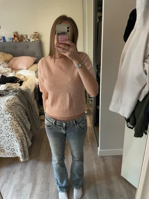 Ljusrosa stickad tröja Gina Tricot - Mysig ljusrosa stickad tröja från Gina Tricot med kortare ärmar och ribbstickade kanter vid hals, ärmslut och nederkant. Perfekt för lager-på-lager och enkel att matcha med jeans eller kjol.
