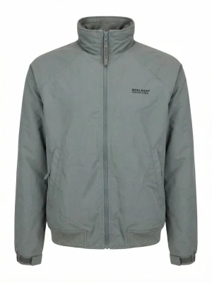 Grå vindjacka från Woolrich - Snygg grå vindjacka från Woolrich med hög krage, dragkedja framtill och två snedställda fickor. Jackan har ribbade muddar vid ärmslut och nederkant samt diskret logga på bröstet. Perfekt för blåsiga dagar och enkel att matcha med olika outfits.