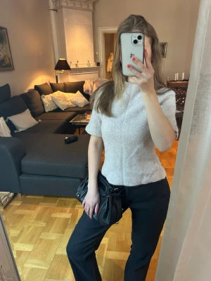 Beige stickad topp med kort ärm - Superfin beige stickad topp med kort ärm och rund hals. Modellen är figurnära och toppen har en mjuk, lite melerad look. Perfekt att styla med både jeans och kostymbyxor för en clean vibe. Passar både till vardags och mer put-together look✨Stylad tillsammans med linnebyxorna i min profil!